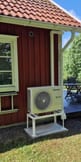 Luftvärmepump vid villa – energieffektiv uppvärmning Installerad luftvärmepump utomhus vid villa – ny energieffektiv uppvärmningslösning.