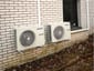 Två Panasonic värmepump-utedelar monterade på fasad Två Panasonic värmepump-utedelar monterade på fasad